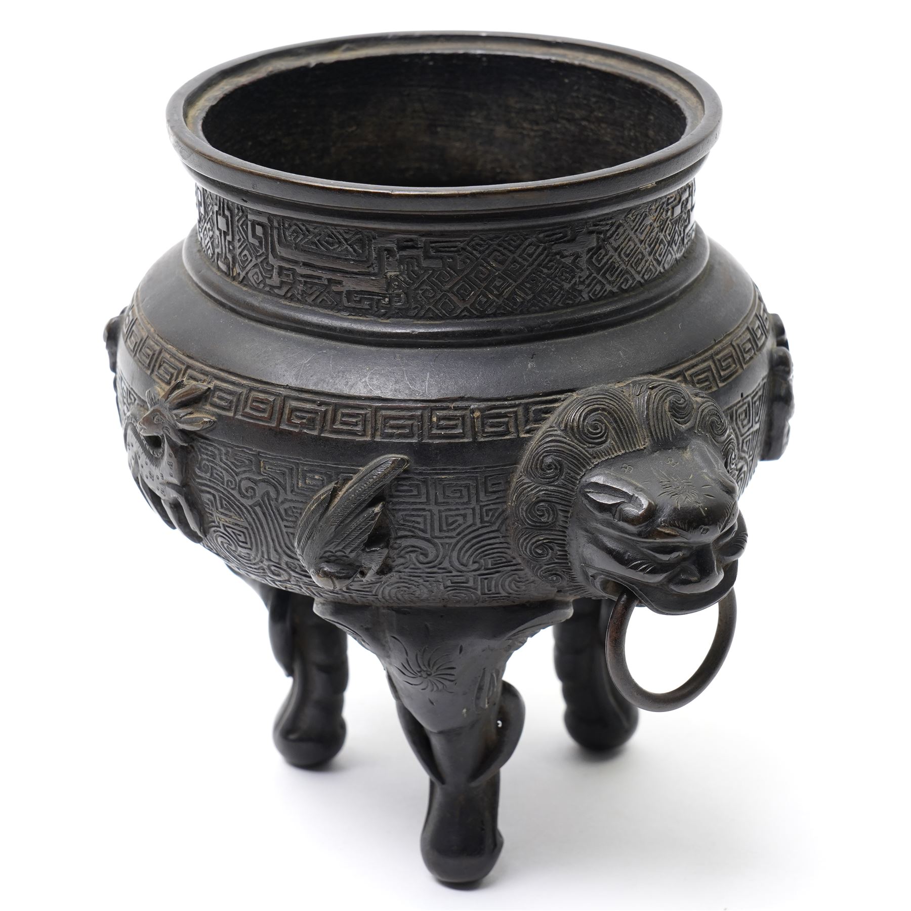 Early 19th century Chinese Qing Dynasty bronze censer, the body of globular form with circular neck and twin cast lion mask ring handles, decorated with applied figures of a monkey, deer and bird, against a key fret detailed ground, the whole upon three zoomorphic elephant feet, H16.4cm D12cm