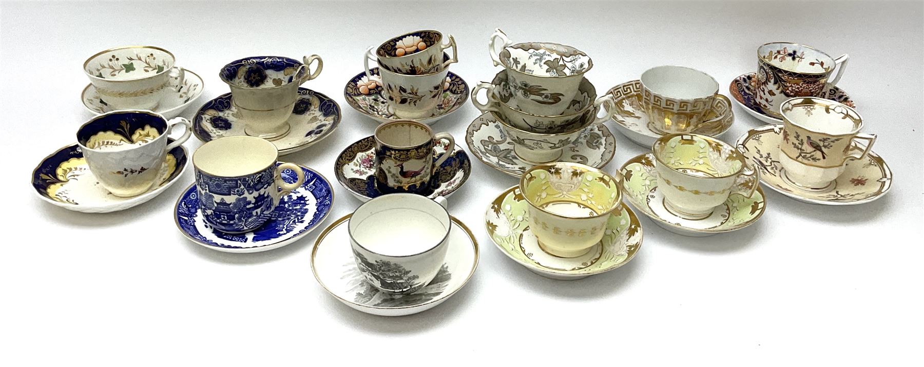 A group of Victorian tea cups and saucers, to include a Derby example decorated in the Imari pallet, a Spode faceted example decorated in gilt with Greek key border and oak leaves, a matched bat printed example, with bute shaped cup, possibly Spode, an example decorated in the Worcester style with reserves of exotic birds and flowers, a Worcester willow pattern example with ring handle cup, etc. 