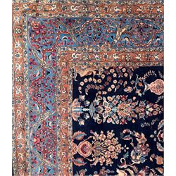 Northeastern Persian Meshed carpet, the deep navy field with a symmetrical floral arrangement of stylised flowerheads, palmettes and scrolling vines issuing from a central urn, enclosed by broad rust and blue borders of floral arabesques and lotus forms, from the region of Meshed