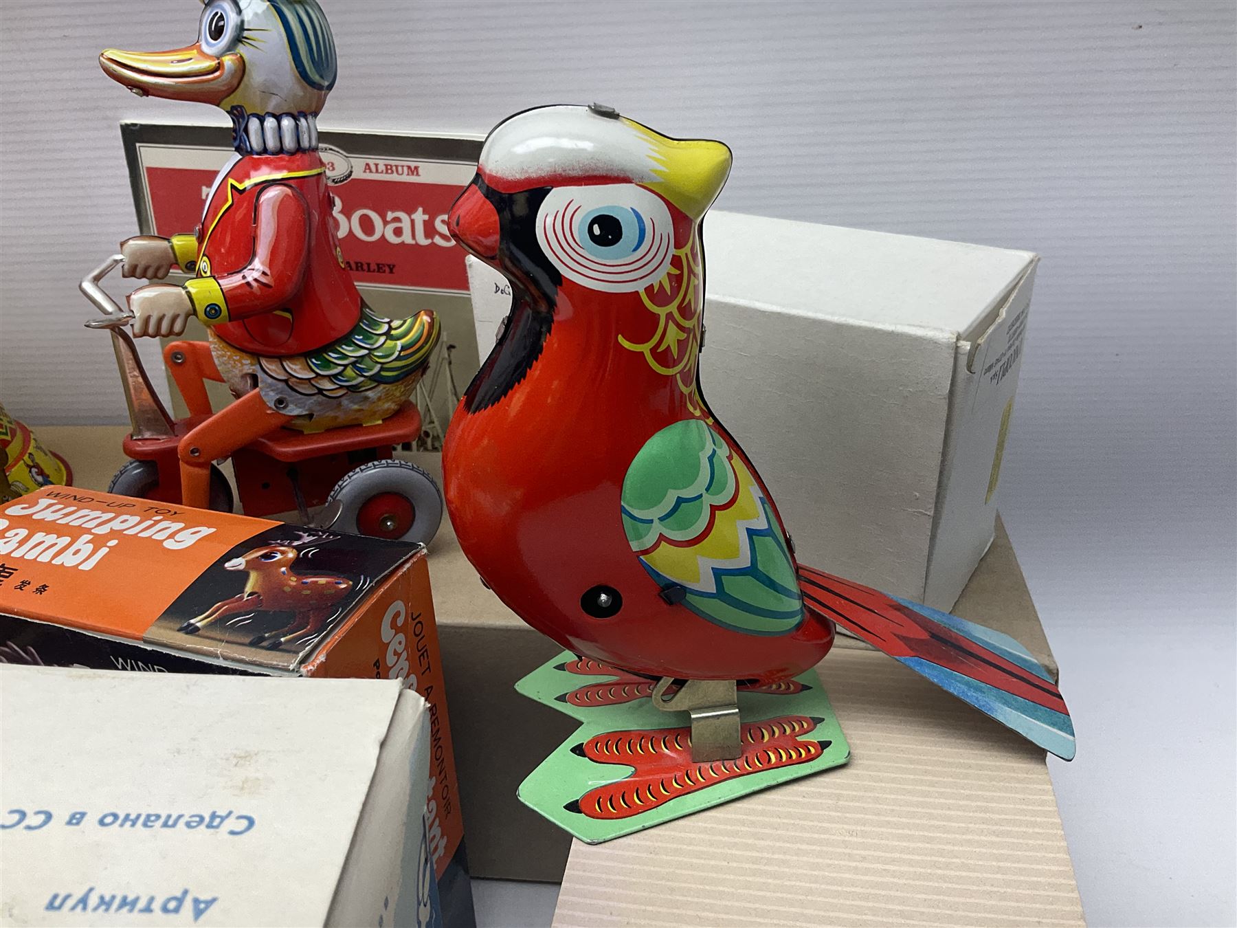 Twenty six tinplate models to include Ferris Wheel and Performing Circus Elephant, marked JW, further similar examples such as Duck on a Bike, Clown on Roller, Carousel; Popeye Tin Speedboat; Looney Tunes Wind Up Cars and Express Train; various international examples, MS107 Jumping Bambi, Pop Pop Boat, jumping frogs, pecking chickens etc; both boxed and loose