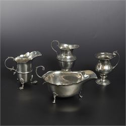 Group of early 20th century silver, comprising sauce boat, with flying scroll handle and upon three pad feet, two small cream jugs and a christening mug, all hallmarked, tallest H10cm