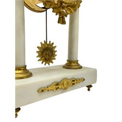French - Late 19th century 8-day white marble and gilt metal portico clock garniture, the clock surmounted by an urn and raised on a pair of cylindrical pillars above a rectangular plinth base, white enamel dial with Arabic numerals and floral garlands, twin train countwheel striking movement, striking the hours and half hours on a bell, with a sunburst pendulum and gilt Louis XVI hands, garniture with matching twin light candelabra. With Key.   Candelabra H 30cm.