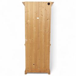 Contemporary stripped pine bookcase cabinet, the upper section with arched frieze and open shelving flanked by barley twist columns, over a single door cupboard base with matching twist supports and fielded panel door