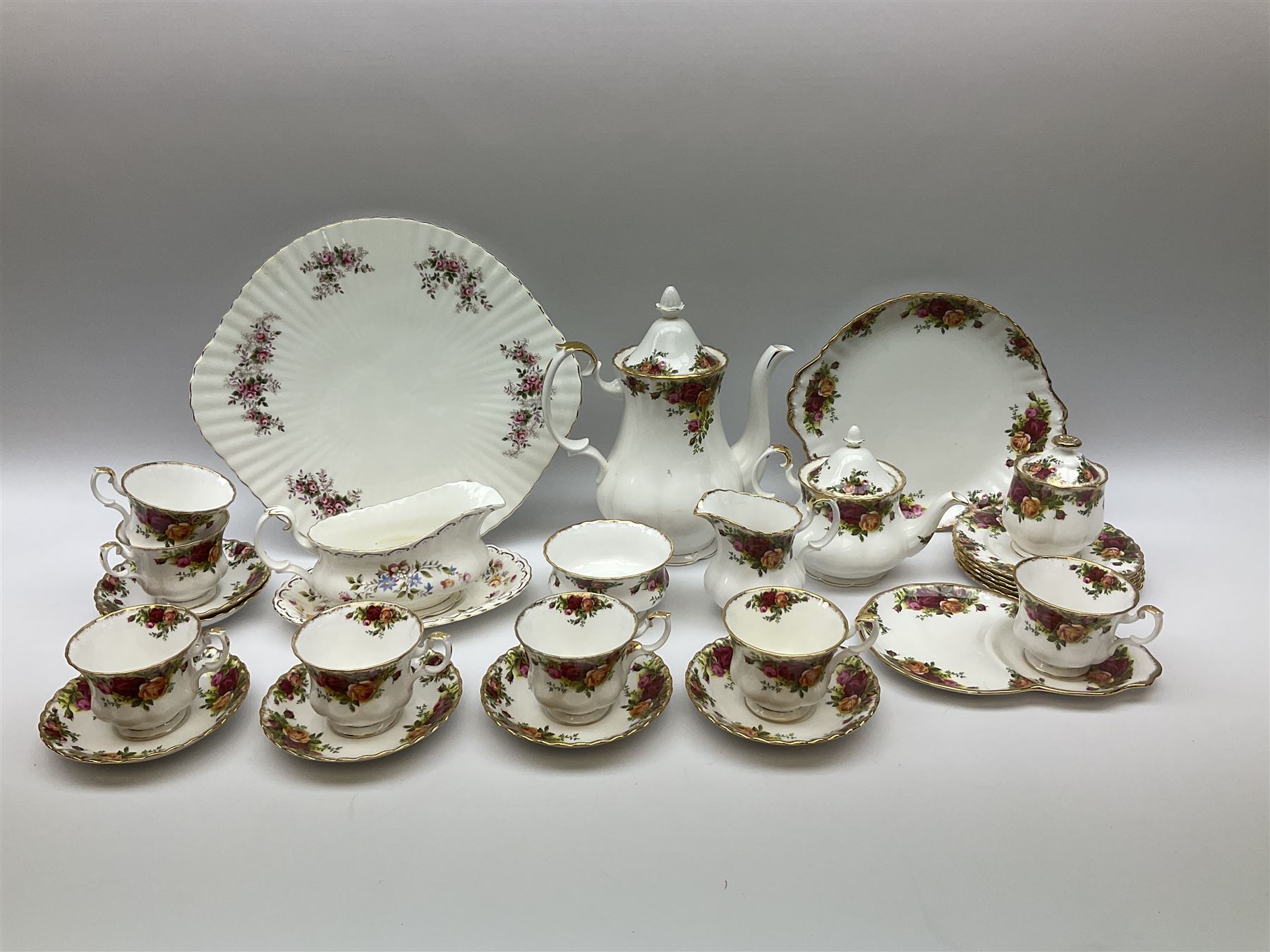 Royal Albert Old Country Roses pattern tea set, comprising teapot, coffee pot, six teacups and six saucers, five side plates, further teacup with joined saucer and side plate, open sucrier, milk jug, cake plate, and preserve pot and cover, together with Royal Albert Jubilee Rose pattern sauce boat and stand, and Royal Albert Lavender Rose pattern cake stand. 
