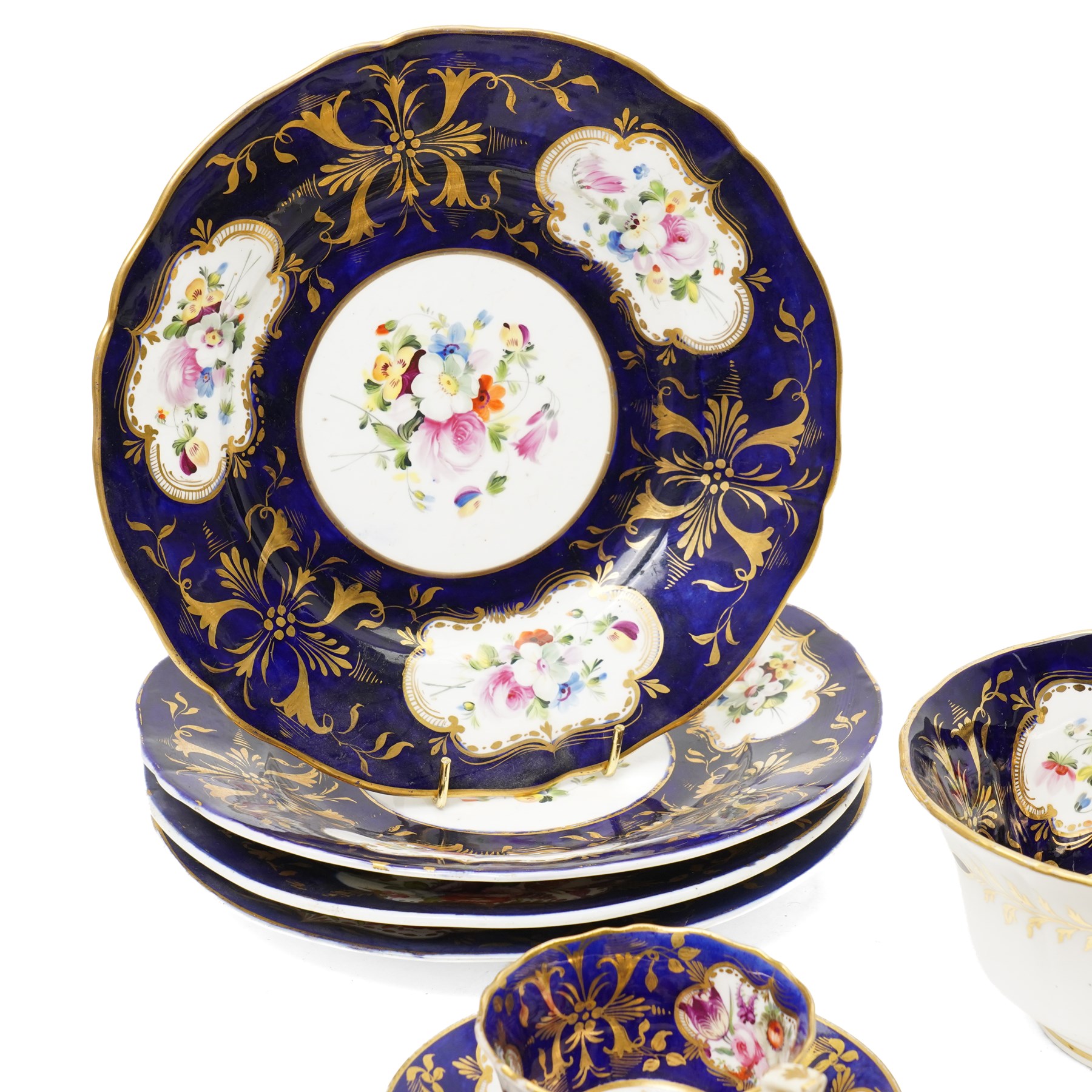 Collection of early 19th century Coalport pattern tea ware decorated with panels of flowers within a blue and gilt surround comprising eight tea cups, three coffee cups, eight saucers, four large plates, two handled sucrier and cover, milk jug and slop bowl and a similar small dish with loop handle