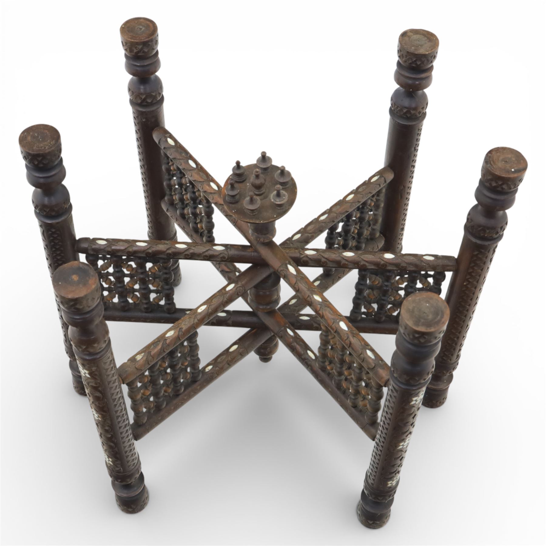 20th century Eastern brass charger topped table, the circular brass trap chased with an elephant, palm tress and flowering vines, supported upon a folding stand with six turned legs with inlaid detail, united by turned supports