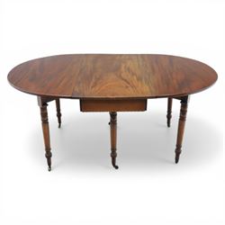 Early 20th century mahogany inlaid oval drop leaf dining table, the crossbanded and line inlaid top with twin hinged leaves (extends to 165cm), plain frieze centred by inlaid panel with stylised star motif, raised on four ring turned tapering supports terminating in brass caps and castors