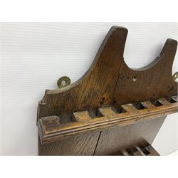 George III oak spoon rack and candle box, the rectangular backplate with shaped  pediment and two six aperture spoon racks, above a candlebox with hinged cover, with various brass spoons and a pair of brass candle snuffers, H56.5cm, W35cm, D14cm 