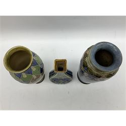 Two Royal Doulton stoneware vases, the first example with tubelined floral decoration, the second with Art Nouveau decoration, together Doulton Lambeth vase of flattened form with foliate decoration on a green ground, all with impressed mark beneath, tallest example H26cm