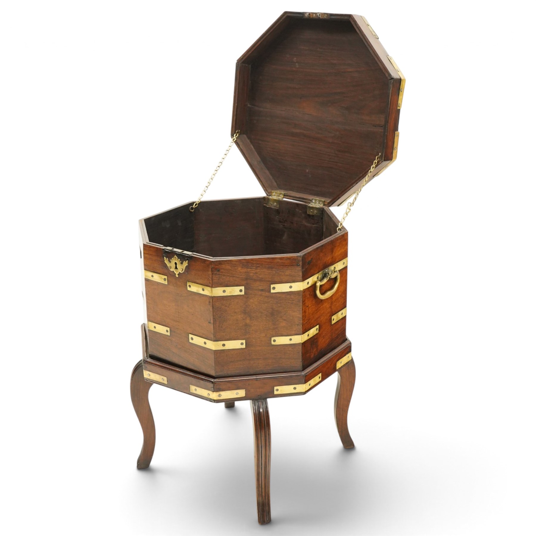 Late 18th century Anglo-Indian padouk and brass-bound octagonal cellarette or wine cooler, the hinged lid enclosing a vacant interior, the panelled body with applied brass strapwork, pierced escutcheon and side carrying handles, raised on a separate stand terminating to four fluted and reeded cabriole supports