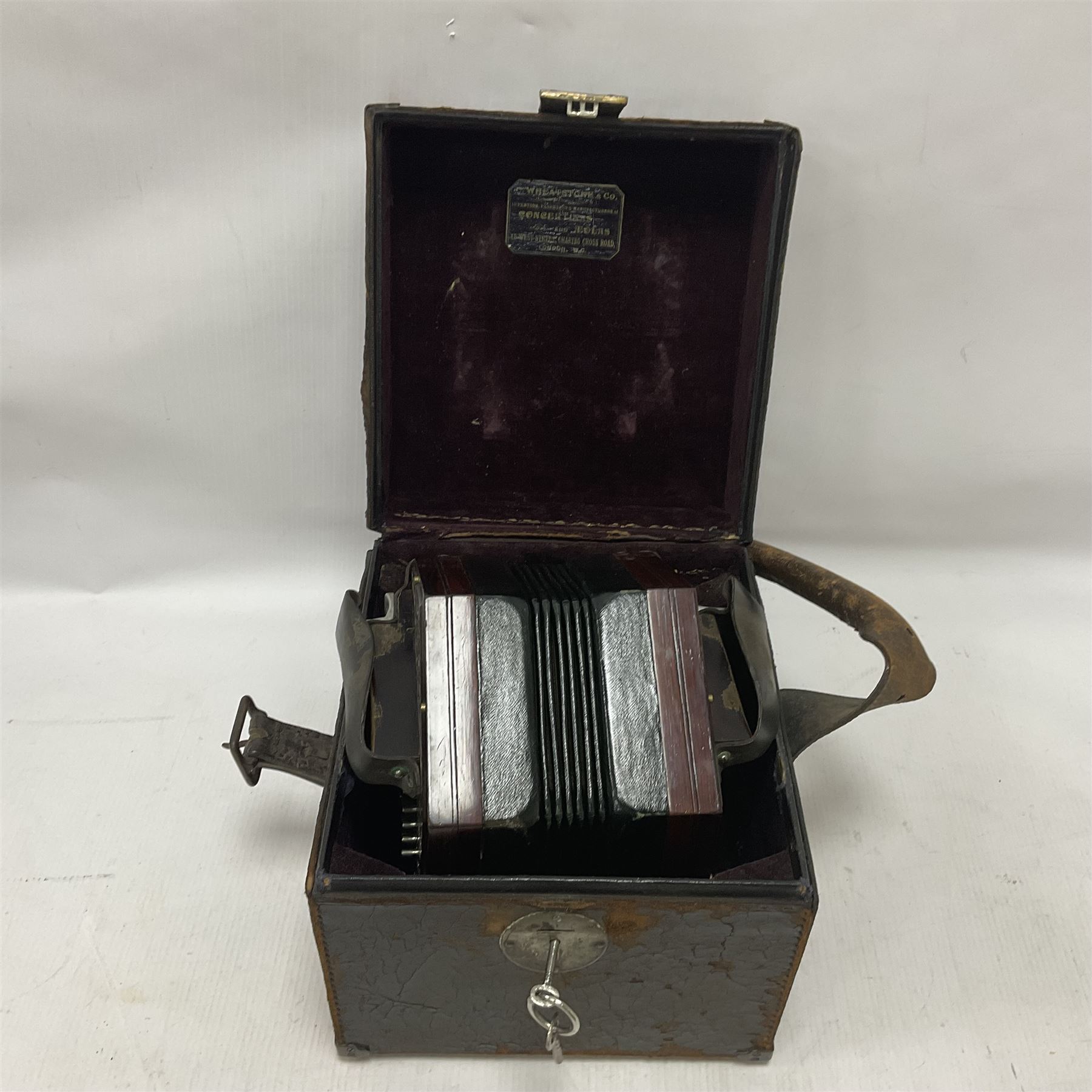 Wheatstone & Co McCann duet system concertina, no 25549, circa 1912, with fifty five metal buttons, hexagonal and chrome plated fretwork ends and six fold bellows, bearing plaque C Wheatstone & Co Inventors, Patentees & Manufacturers 15 West St, Charing X Rd, London; WC, with original case