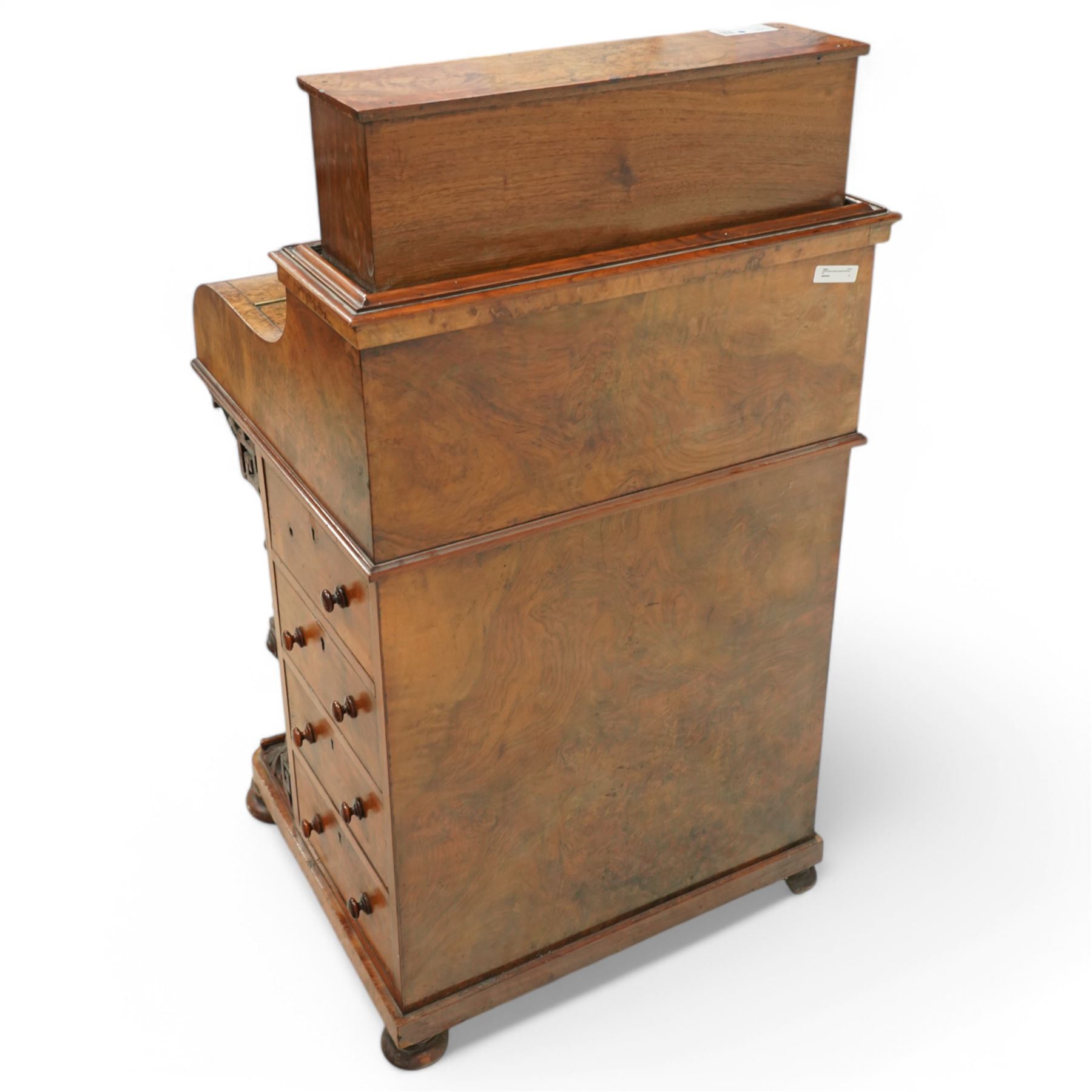 Victorian figured walnut piano top Davenport desk, hidden compartment lifting to reveal small drawers and pigeonholes, the piano lid enclosing drawers and sliding top with hinged leather writing surface, the right-hand side fitted with four drawers, on compressed bun feet 
