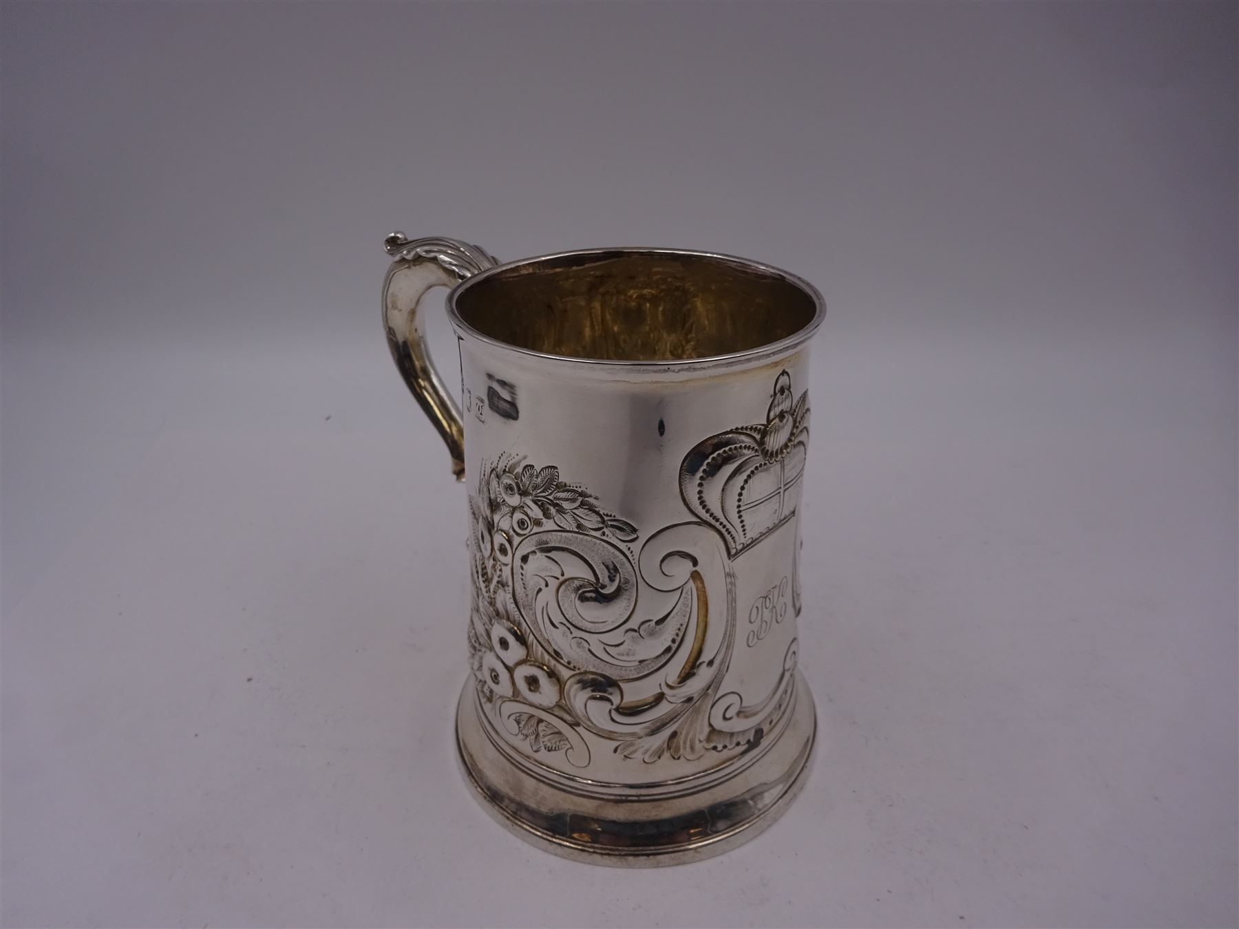 George III silver tankard, of slightly tapering cylindrical from, with chased and repousse crown above a monogrammed cartouche and floral, foliate and C scroll decoration, with acanthus capped C scroll handle, hallmarked WT, possibly William Turton, London 1774, H11.5cm