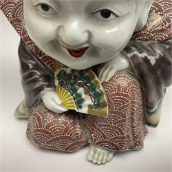 Japanese Fukusuke good fortune figure, modelled as a kneeling male figure holding a fan, dressed in traditional Samurai robes, H15.5cm