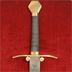 Three replica gauntlets, each housed upon a red wall shield, two with daggers, the third with a sword, largest H102cm