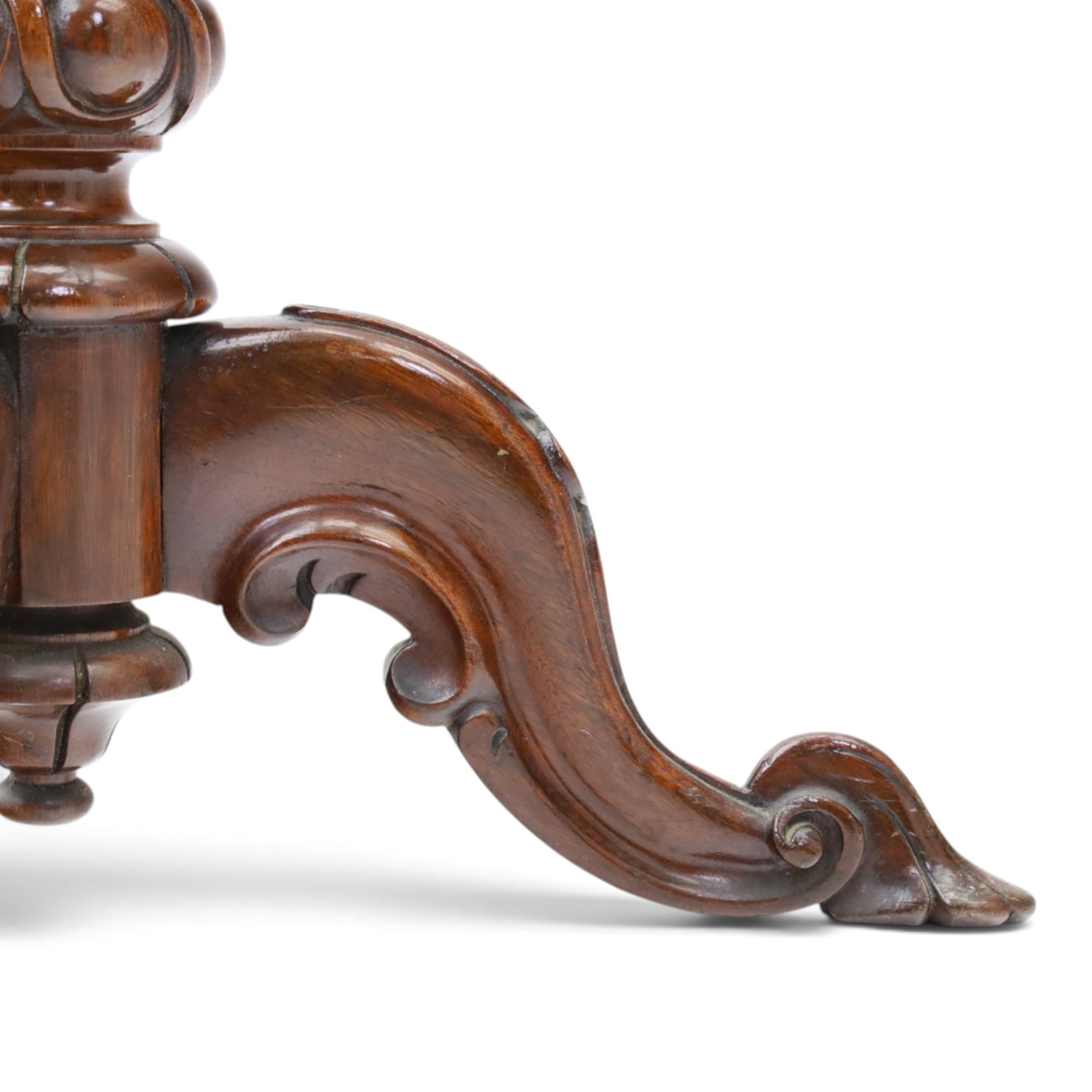 Two Victorian mahogany pole screens, comprising an oval example with floral needlework panel and carved cresting, on brass pole and tripod base with scroll carved supports (H 153cm, W 43cm, D 43cm); and a rectangular example with glazed architectural print panel, on brass pole, turned column and conforming scroll carved tripod base (H 147cm, W 38cm, D 38cm)