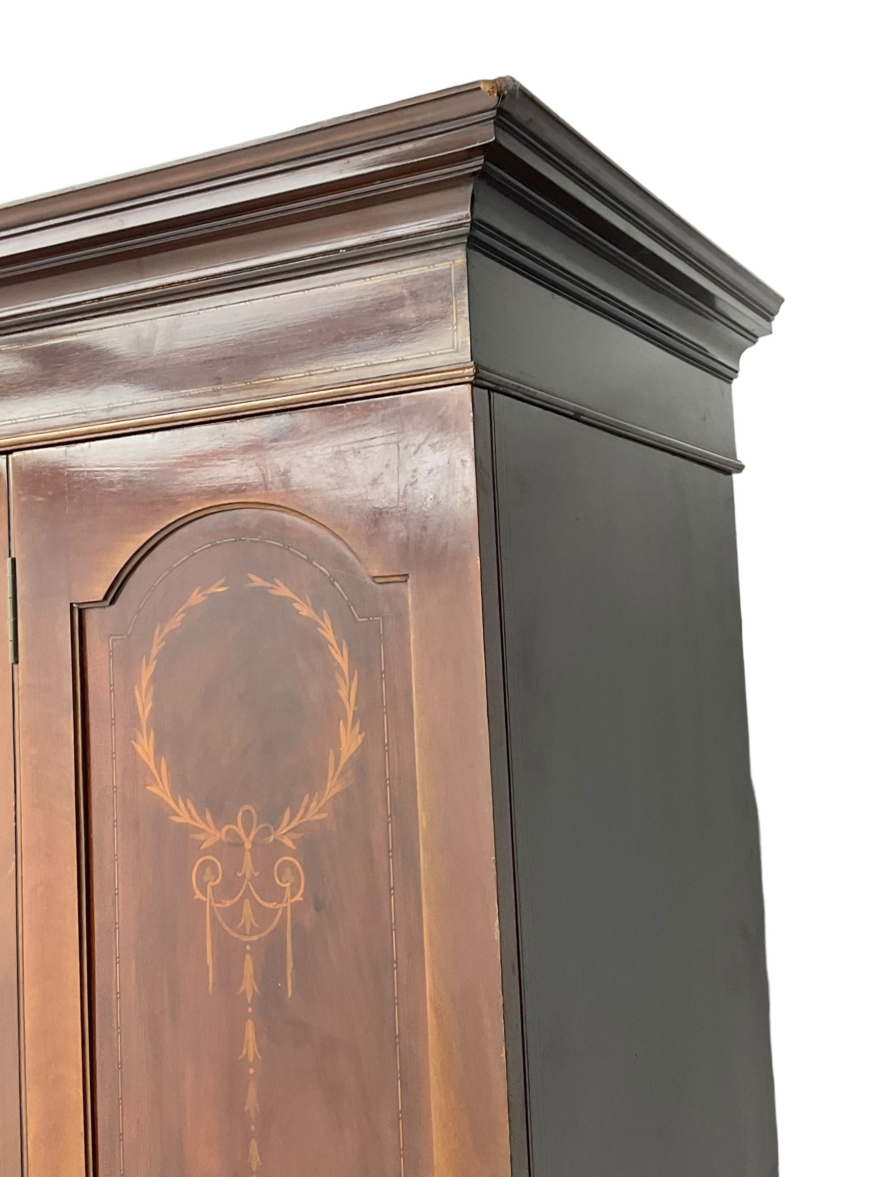 Edwardian inlaid mahogany wardrobe, projecting moulded cornice over central bevelled mirror glazed door, panelled uprights inlaid with trailing bellflowers and foliate decoration, the skirted base fitted with single drawer 
