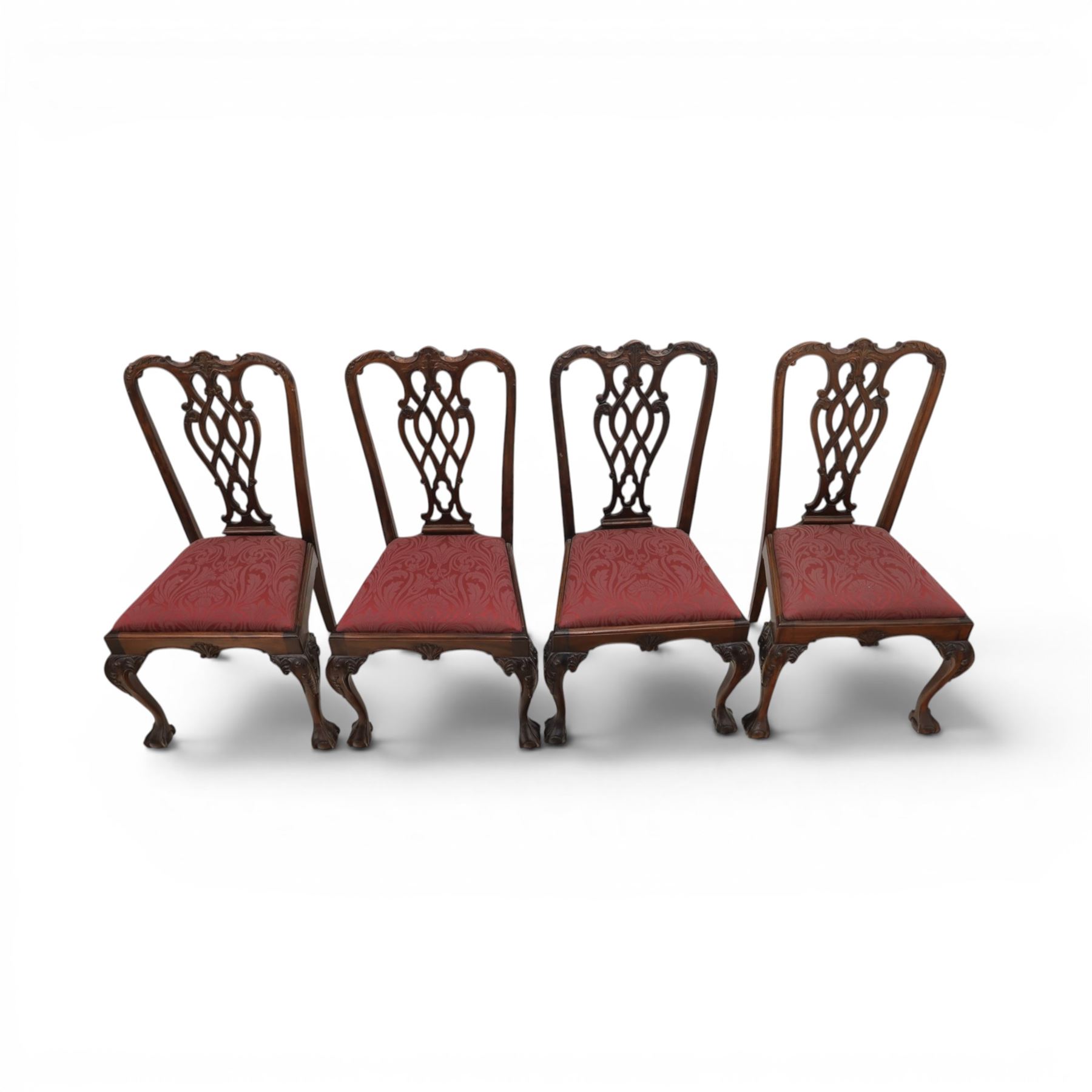 Chippendale design set of ten (8+2) mahogany dining chairs, serpentine cresting rails with carved detail over pierced ribbon-tied splats, red damask upholstered drop-in seats, on cabriole supports with acanthus carved knees and claw and ball feet