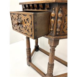 20th century oak credence table, canted top over single drawer, the front relief carved with scrolled leafage, split turned mounts, turned supports joined by moulded stretchers