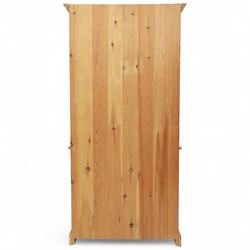 Contemporary pine kitchen dresser, moulded cornice over open plate rack with shaped frieze and two fixed shelves, enclosed lower section with panelled twin doors and shaped plinth base