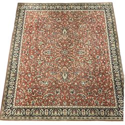 Large Persian design red ground rug, the field decorated with interlacing branches and stylised plant motifs, repeating border with further plant and floral motifs