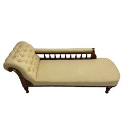 Late Victorian oak chaise lounge, the scrolled back carved with floral motif, upholstered in buttoned cream fabric with repeating pattern, balustrade support rest, on turned feet, sprung seat 