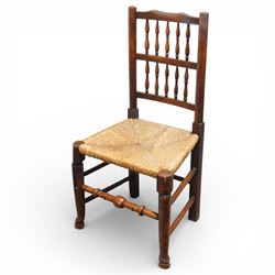 Set of five 19th century elm spindle back chairs, with shaped crest rails above double rows of turned spindles, rush seats, turned legs joined by stretchers supported on turned pad feet