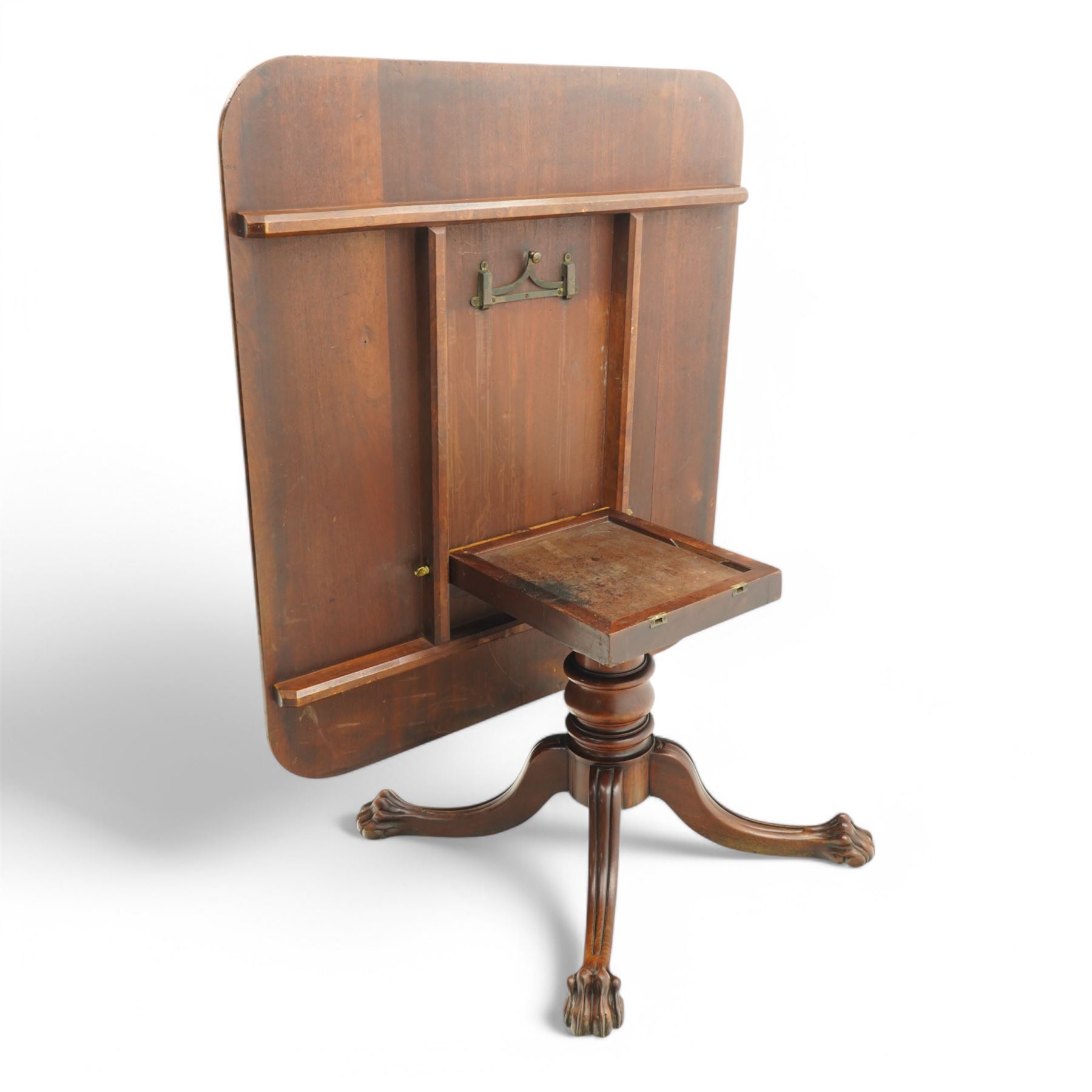 Large Regency mahogany breakfast table, figured rectangular tilt-top with rounded corners, on wide turned pedestal with four out-splayed moulded supports, paw carved terminals with recessed castors 