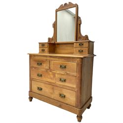 Victorian waxed pine dressing chest, raised swing mirror with shaped flower head carved pediment, small trinket drawers over two short and two long drawers, skirted base, on turned feet