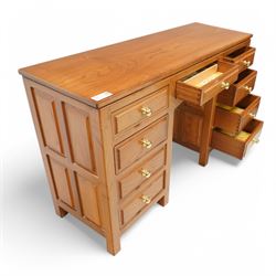 Craftsman made - elm kneehole dressing table, rectangular top over nine drawers, panelled sides, on stile supports 