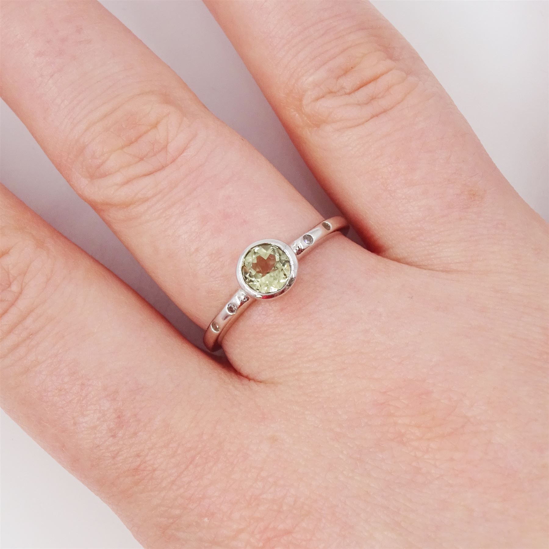 9ct white gold csarite and diamond ring, single round cut csarite with two rubover set diamonds set either side, Birmingham 2016