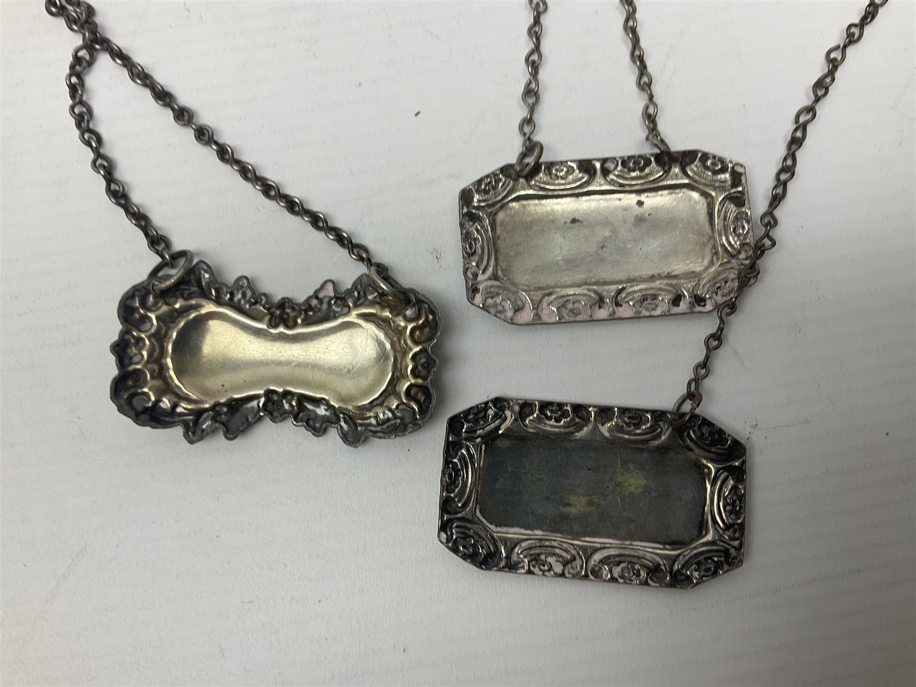 Silver plated tray, with shaped rim and embossed with a dog and crown to centre, stamped Valenti, together with three silver plated decanter labels, two port and one Bucellas, a plated cream jug with embossed floral decoration and a pair of plated fish knives engraved with double headed eagle to handle, tray W25.5