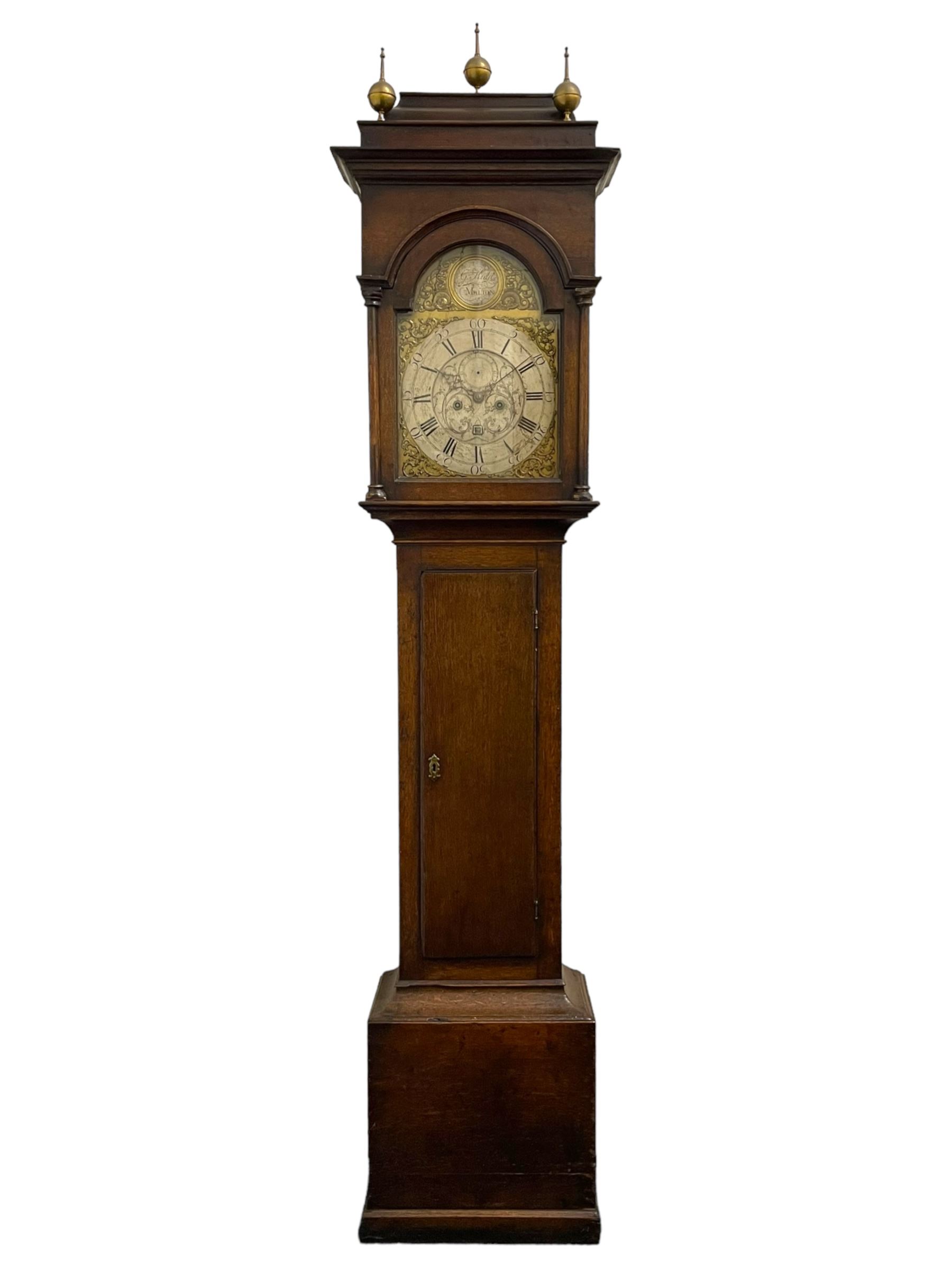 Gilbert Kidd of Malton (North Yorkshire) - late 18th century oak 8-day longcase clock c1780,  with a tall double caddy top and later brass ball and spire finials, break arch hood door beneath with attached pilasters and wooden capitals,  plain trunk with a long flat topped door, raised on a square plinth with applied skirting,  brass break arch dial with the makers name to the silvered boss in the break arch, engraved and silvered dial centre and chapter ring, with cast spandrels and matching steel hands, subsidiary seconds dial and square calendar aperture, dial pinned directly to a rack striking movement with a recoil anchor escapement, sounding the hours on a cast bell. With pendulum and weights.
The Kidd family were a prolific family of provincial clockmakers working in Malton from the mid 18th century until the early 19th century. Many of their clocks are simply signed 