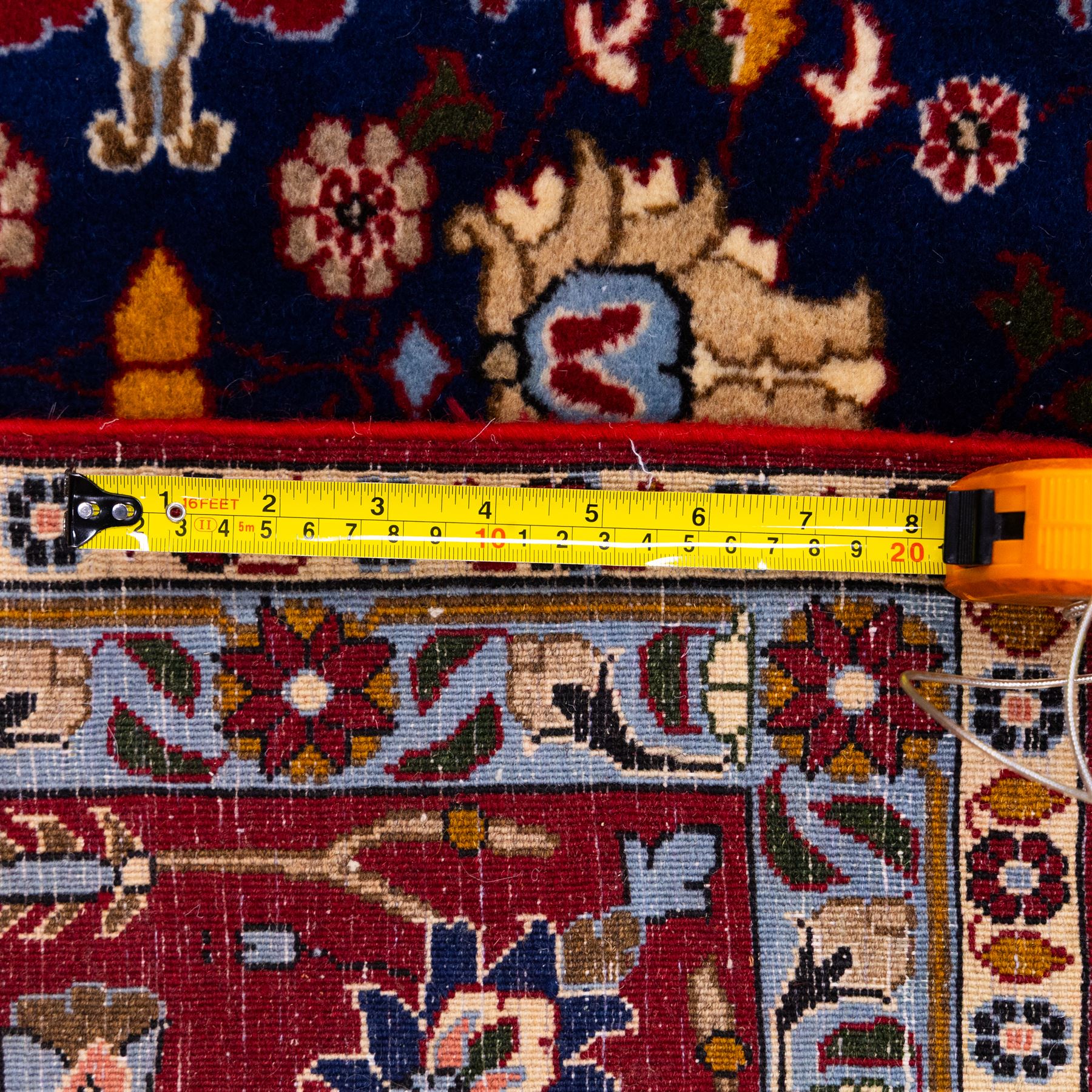 North Central Persian Veramin hand-knotted rug, deep indigo field decorated with an all-over lattice of stylized floral and palmette motifs issuing from an angular vine ornament, enclosed by a broad madder-red border of palmettes and scrolling vine devices between multiple guard stripes, with cotton fringe ends 