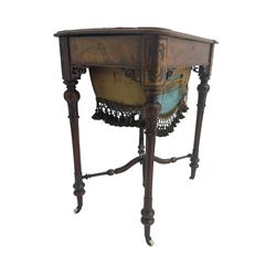 Victorian figured walnut work table, hinged rectangular top inlaid with scrolling foliate decoration, the fitted interior with satinwood fretwork lids, over the upholstered basket well with fringing, raised on turned and fluted supports united by shaped X-stretcher, on ceramic castors