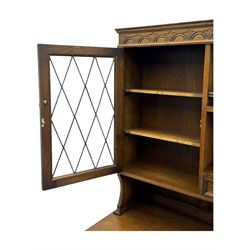 Large mid-20th-century oak dresser with two astragal glazed doors between gallery shelf and lower shelf, with three short drawers and lower section with four drawers and three double-panelled linen-fold hinged cupboard doors 