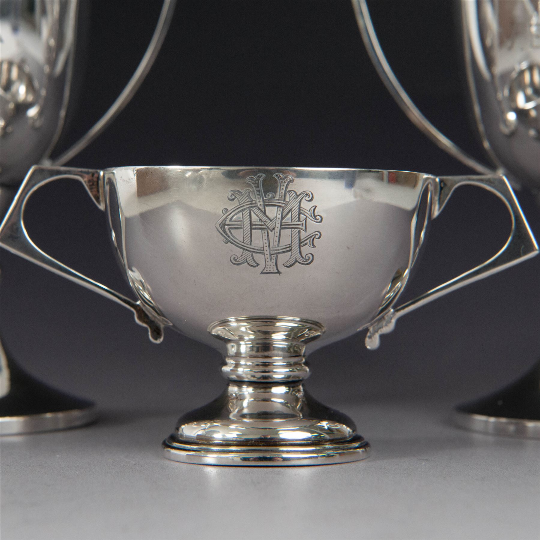 Pair of 1930s silver trophies, with angular handles and presentation engravings to body, hallmarked William Hair Haseler, Birmingham 1938, together with a similar smaller example, hallmarked Charles Boyton & Son Ltd,  London 1927, tallest H13cm