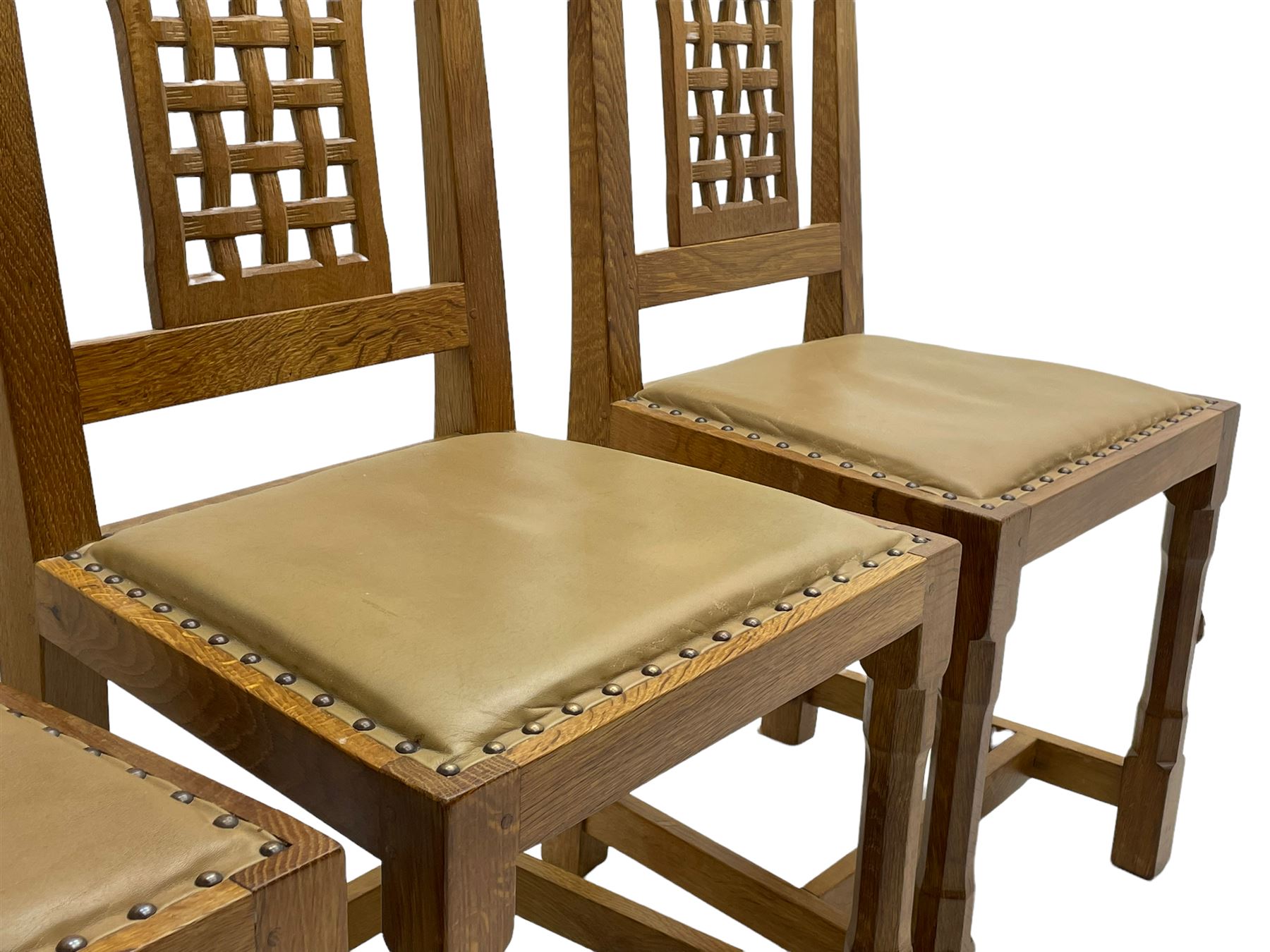 'Rabbitman' set of eight oak dining chairs, pierced lattice backs, upholstered seats with studwork band, octagonal front supports joined by stretchers, carved with rabbit signature, two carvers and six side chairs, by Peter Heap of Wetwang
