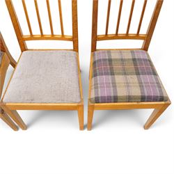 Acorn Industries - set of eight oak dining chairs, the shaped cresting rail over a fluted stick back, the drop-in seats upholstered in contrasting form with four pale mauve and four in purple tartan, raised on square supports, carved with acorn signature, by Alan Grainger, Brandsby