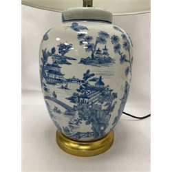 Pair of blue and white table lamps, each of ovoid form, decorated with a continuous landscape, raised upon circular gilt base, excluding fittings H35cm 