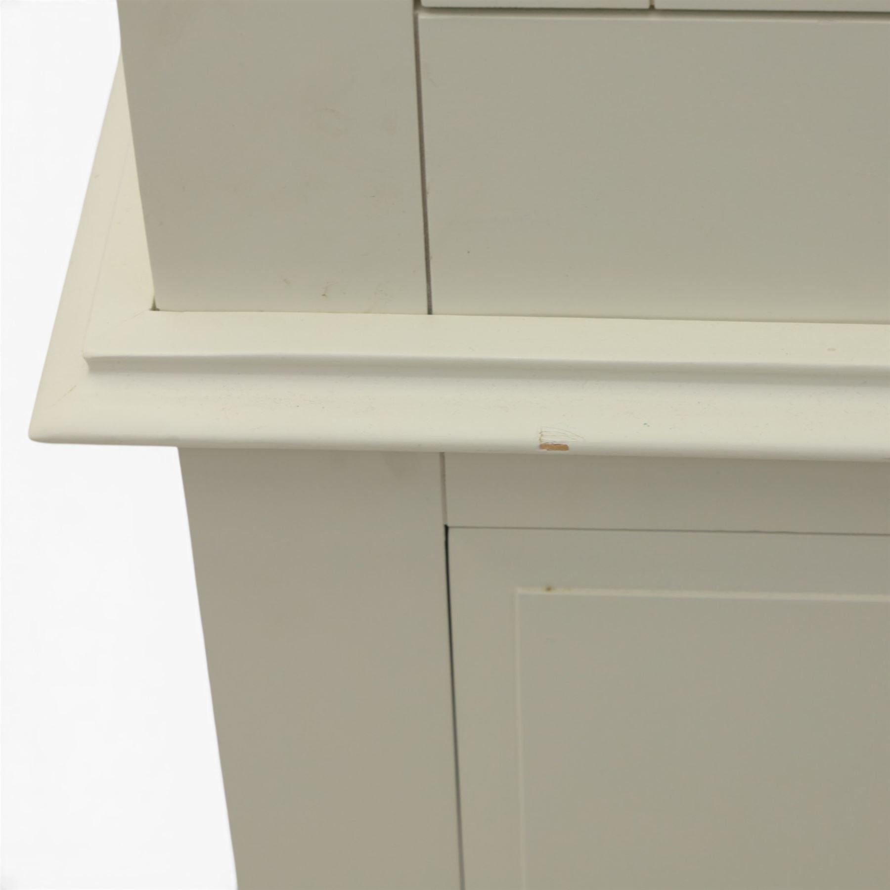Modern white three door wardrobe, with two hanging section and shelving area, above a long drawer and a short drawer to the base, raised on a moulded plinth