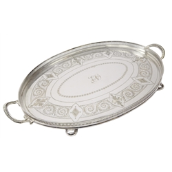  Edwardian Walker & Hall silver-plate galleried edged tea tray of oval form with a pierced gallery, bright cut decoration, with an inner scroll banding and central initials, beaded scroll handles, on bun feet, L54cm   