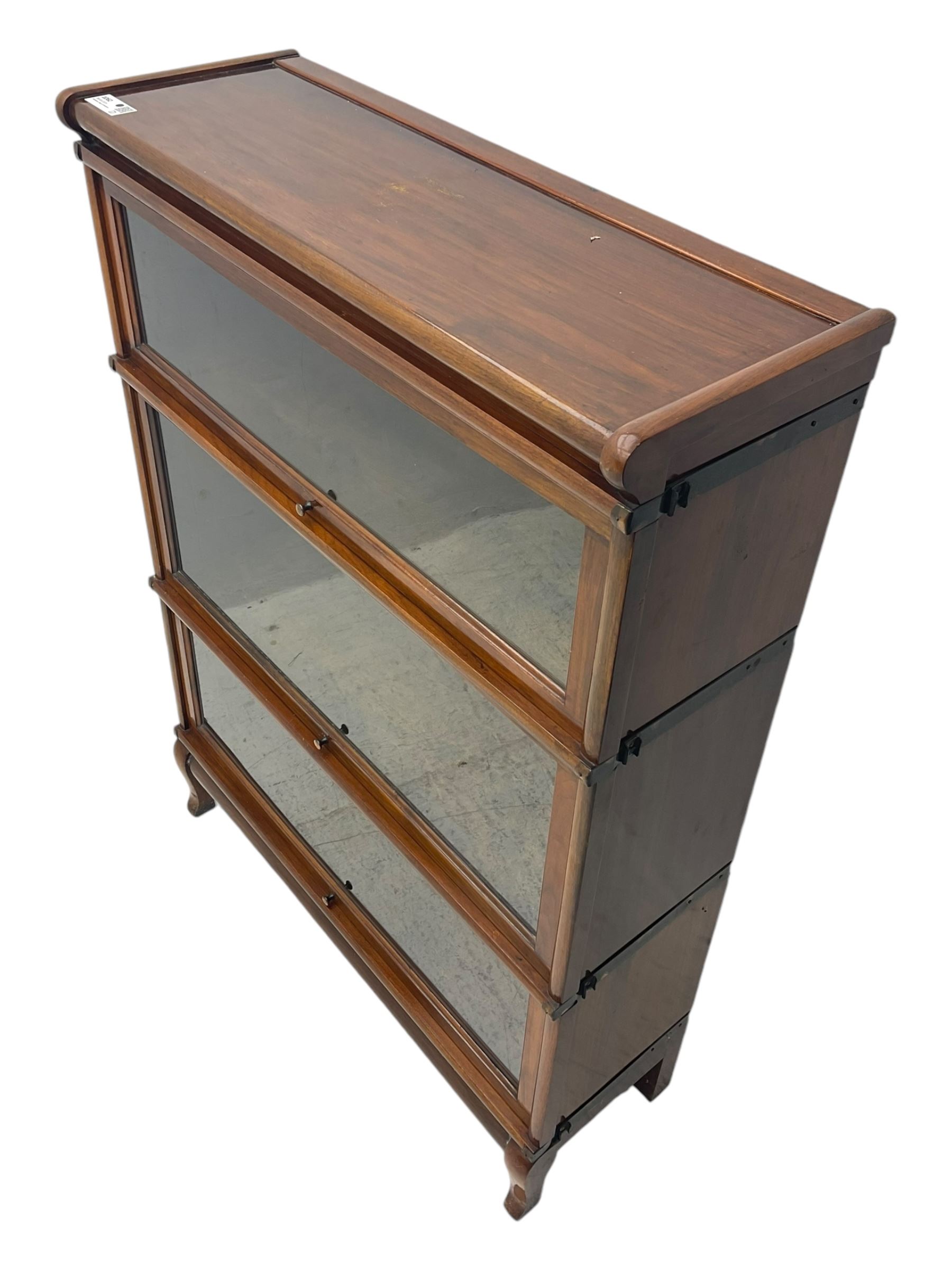 Globe Wernicke - early 20th century mahogany three-tier stacking library bookcase, three glazed sections enclosed by hinged and sliding doors, interior with transfer label, raised on cabriole front supports