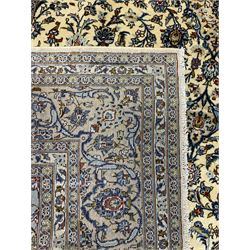 Persian Kashan ivory ground carpet, the field decorated profusely with interlacing branch and stylised plant motifs, scrolling border with overall floral design 