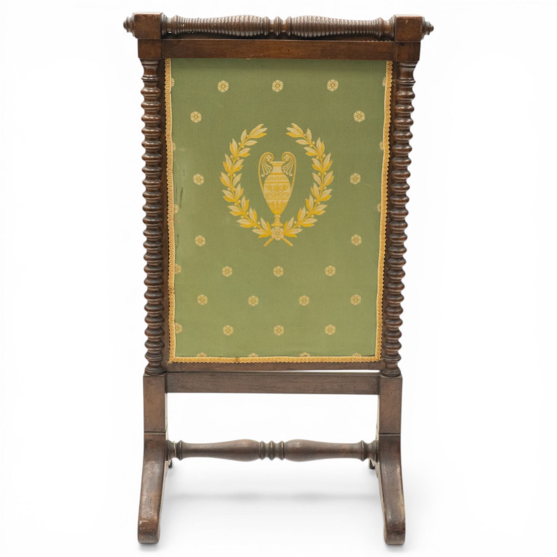 Victorian mahogany firescreen, the rectangular upholstered panel decorated with a Greek urn within laurel wreath on green ground, within spiral turned uprights, on downswept supports united by a turned stretcher