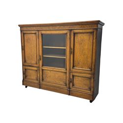 Late Victorian pollard oak bookcase or sideboard, the central glazed door opening to reveal adjustable shelves and interior makers label 
