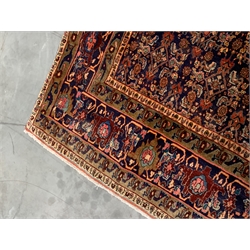 Fine Persian Bijar rug carpet, red ground lozenge with inner central lozenge on dark blue field, profusely decorated with herati and stylised motifs, repeating guarded border, 294cm x 235cm