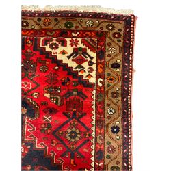 Persian Hamadan rug, red ground field decorated with pole medallion and stylised flower head motifs, the border decorated with Boteh and floral motifs