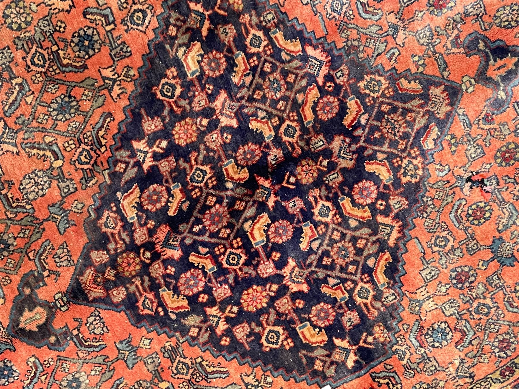 Persian Zanjan pale red ground rug, lozenge medallion and field decorated with floral Herati motifs, the border decorated with stylised plant motifs and trailing branches, floral pattern guard stripes