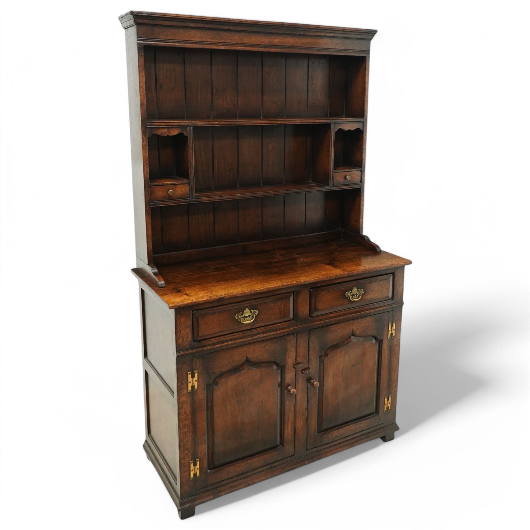 Contemporary georgian style oak dresser, open rack top with two shaped shelves and small side drawers, base with rectangular top over two drawers with brass swing handles, twin arched panelled doors below, on bracket feet